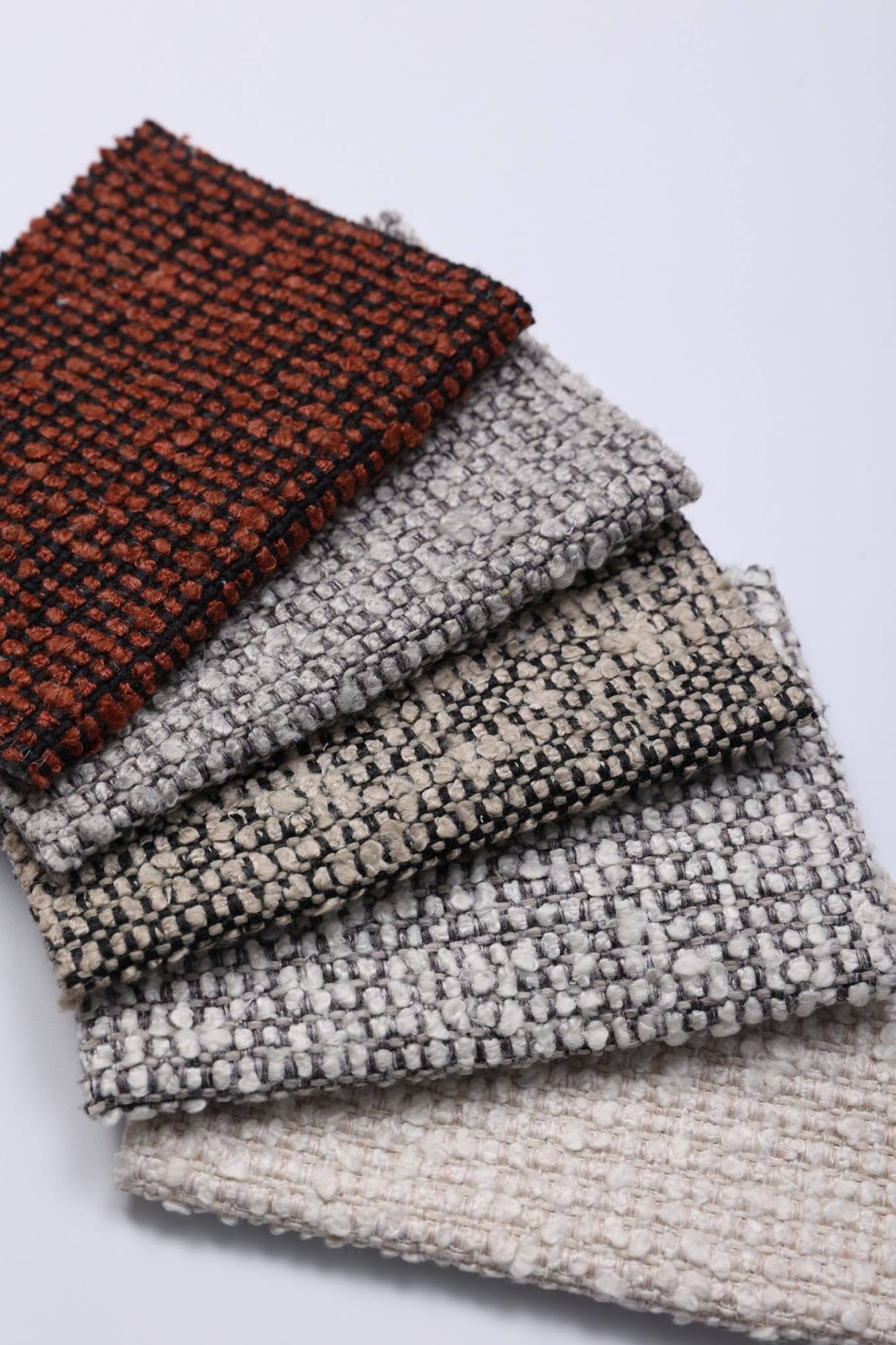 Fan of tweed-like woven swatches from rust to ivory