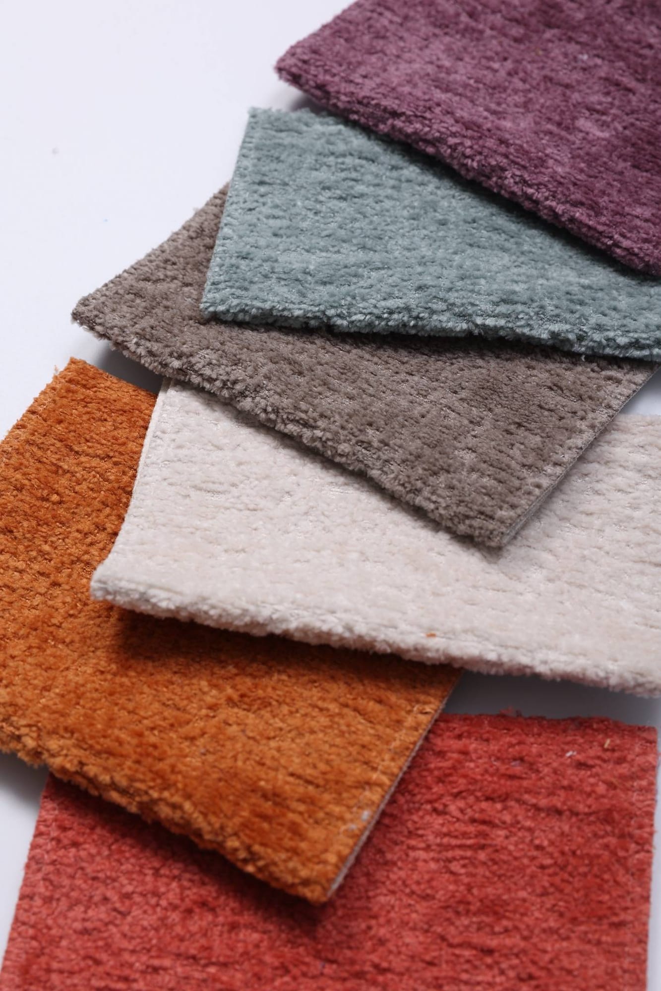 Stacked velvet-touch swatches in plum, aqua, ivory and orange